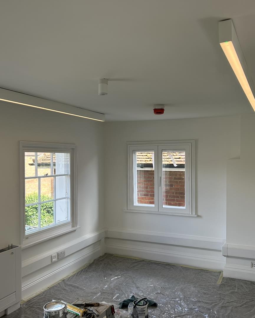 Room with linear LED ceiling light and fire alarm installation