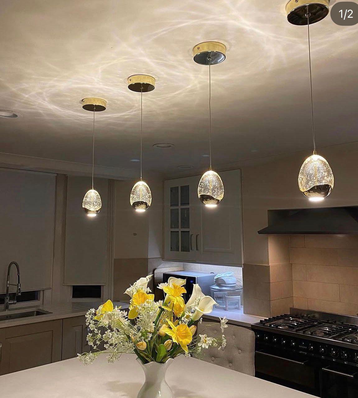 Glass pendant lights over kitchen island by LJK Electrical