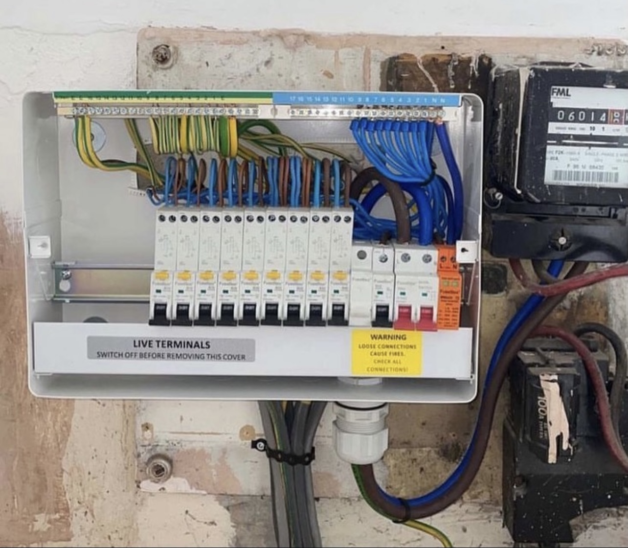 Modern consumer unit with circuit breakers and warning label
